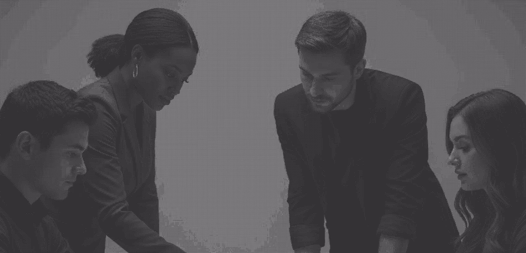 Four young professionals intensely discussing work around a table in a collaborative meeting.